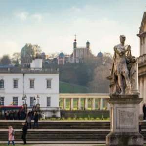 Statue in front of Old Royal Naval College with Royal Observatory Greenwich on the hill in the background