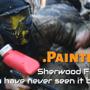 Paintball players in combat gear moving through a themed game zone