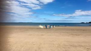 People surfing on beach at Good Trails in Saundersfoot