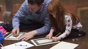 Father and daughter do activity sheet at The National Gallery in London