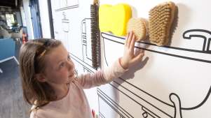 Girl touching brushes at Visit Hillbrush in Wiltshire