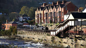 Train at Llangollen Railway passes town