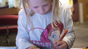 Girl colouring at Jersey Museum and Art Gallery in St Helier
