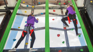 Girls climbing at Clip n Climb Dundonald in Belfast