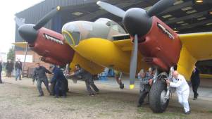 Crew pushing airplane at De Havilland Aircraft Museum in London Colney