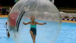 Girl in zorb ball on water at Arundel Lido