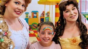 Little girl next to two princesses dressed up at Wacky Kingdom
