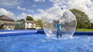 Girl in zorb on water at National Botanic Garden of Wales in Llanarthney