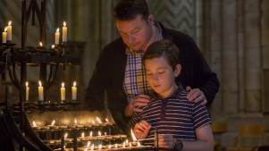 Dad and son lighting candle at Durham Cathedral