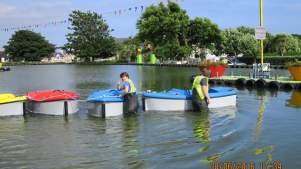 Staff by boats at Onchan Pleasure Park in Onchan