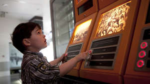 Boy touching machine at National Waterfront Museum in Swansea