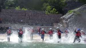 People running through water at Reach Outdoors in Paignton