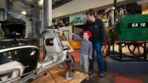 man and child looking at classic car