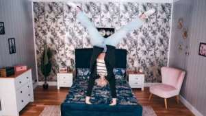 woman doing a handstand on a bed