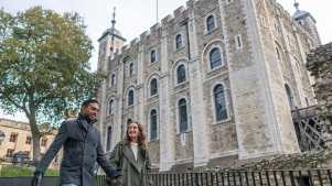 Visitors walking past the iconic Tower of London battlements