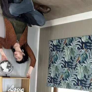 person sitting on the ceiling (illusion) touching a globe