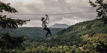 Someone going across a zip wire at Zip World Fforest