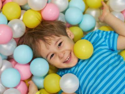 Little boy in soft play ball pit