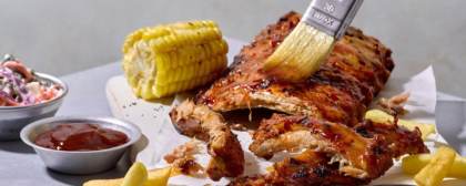 picture of ribs, corn on the cob, chips and bbq sauce