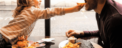 daughter feeding dad a fry