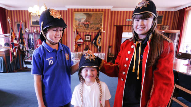 Kids wear infantry helmets at the Lancashire Infantry Museum