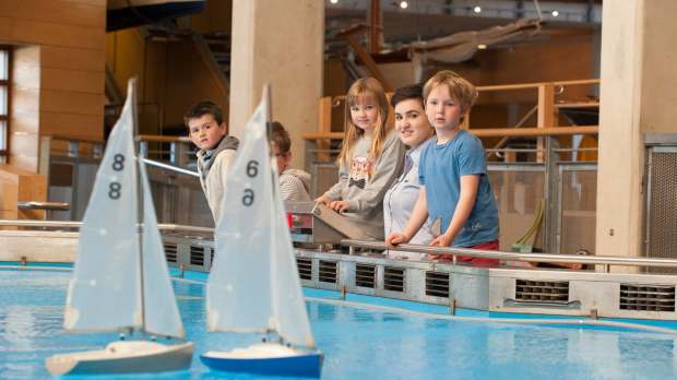 Kids watching boats on indoor lake at National Maritime Museum Cornwall in Falmouth