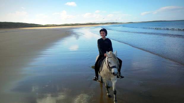 Girl horse riding on beach at Island View Riding Stables in Ballyshannon