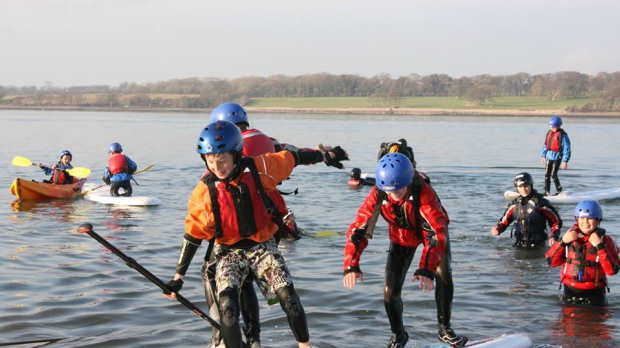 Kids paddle boarding at Plas Menai National Outdoor Centre in Caernarfon