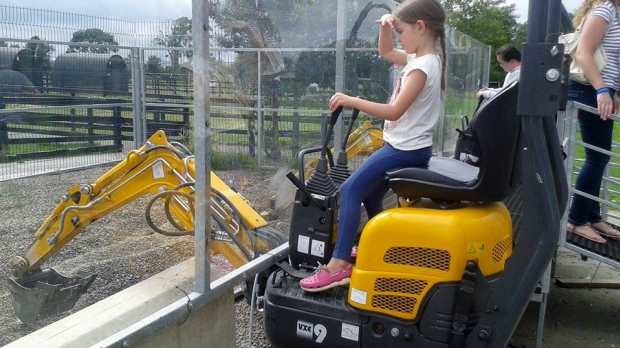 Girl using digger at Kia Ora Minifarm in Gorey