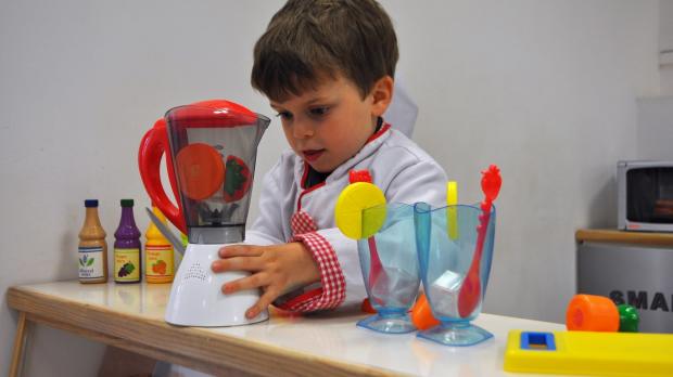 Boy in role play kitchen at Little Street in Chichester