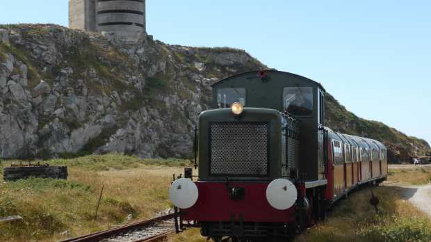 Train from The Alderney Railway passes Fortress Alderney in Guernsey
