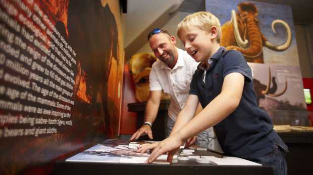 Dad and son doing puzzle at Dinosaur Museum in Dorchester