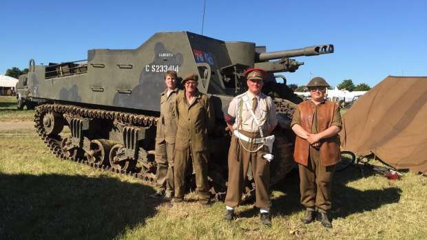 Staff by military tank at Cobbaton Combat Collection in Umberleigh