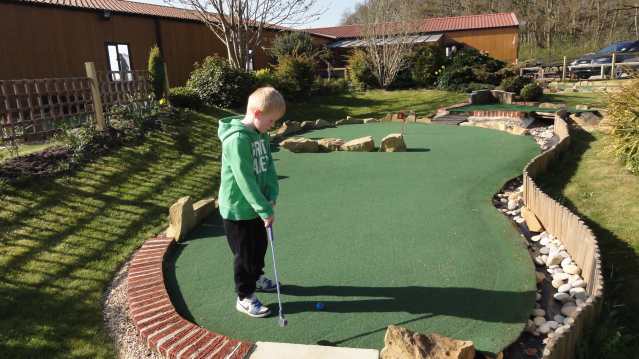 Boy playing golf at Crazy Golf @ York Golf Range