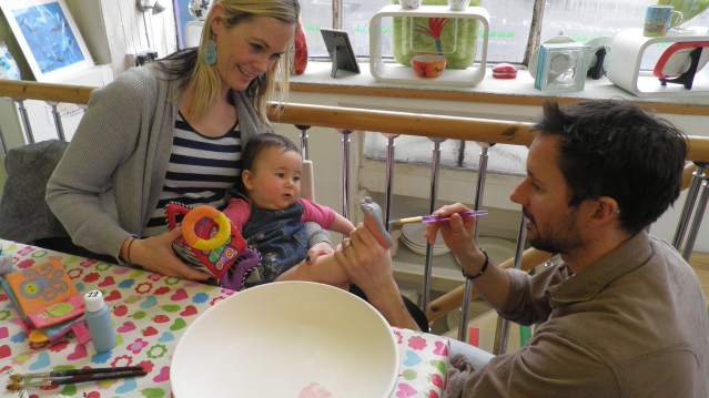 Dad painting baby's foot at The Painting Pottery Cafe in Brighton