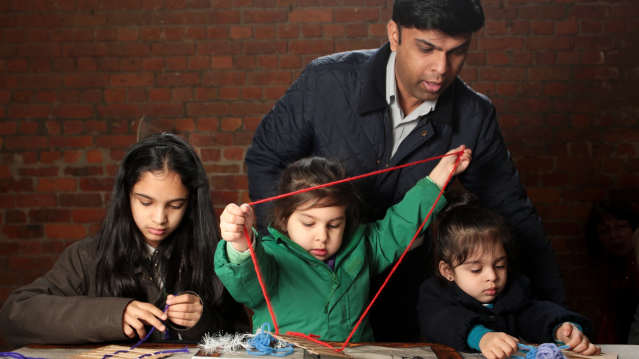 Father and daughters crafting at Museum of Science and Industry in Manchester