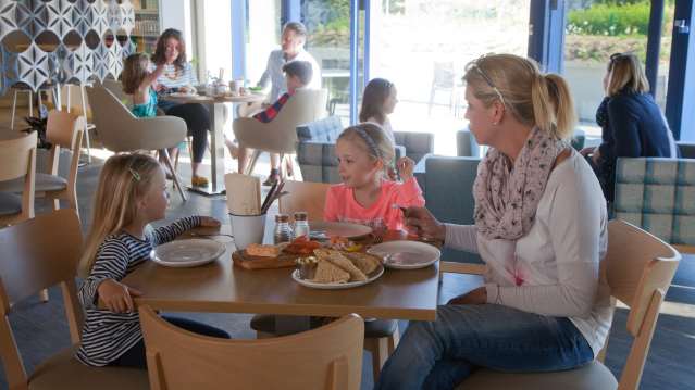 Mum and daughters eating in cafe at Visit Hillbrush in Wiltshire