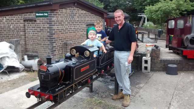 Family by miniature train at Thames Ditton Miniature Steam Railway