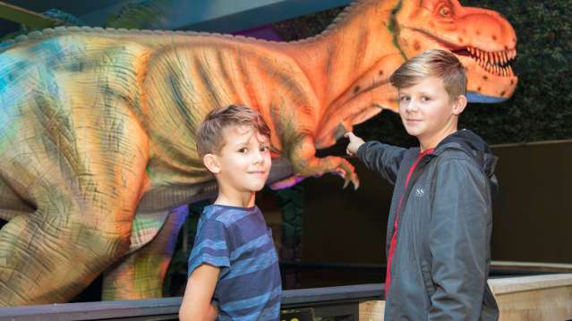 Boys by T-Rex model at Jurassic Journey in Great Yarmouth