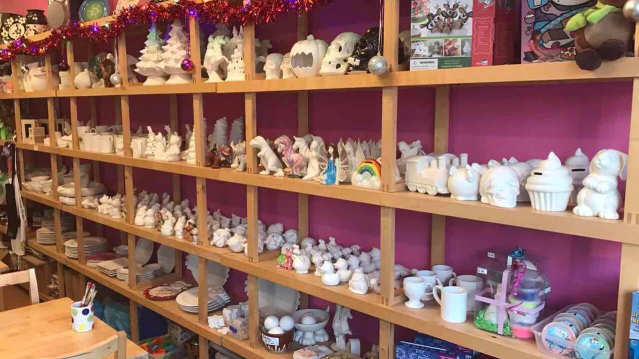 Shelves of pottery and crafts at Paint the Town in Enfield