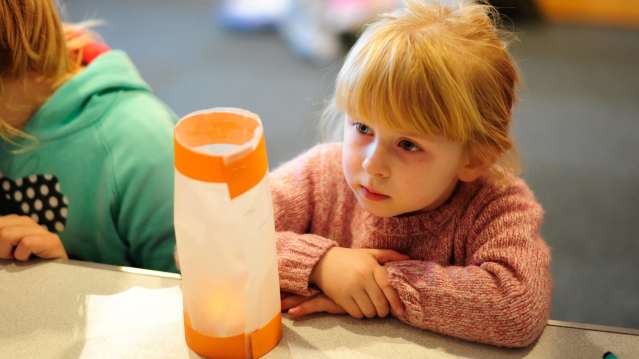 Girl looking at craft at Timespan in Helmsdale