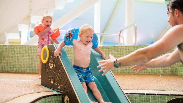 Boy on slide into swimming pool at Tenterden Leisure Centre