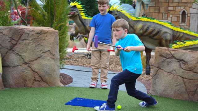 Boys mini golfing at Mighty Claws Adventure Golf in Bournemouth