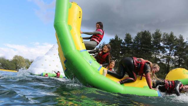 Girls on inflatable on lake at New Forest Water Park in Fordingbridge
