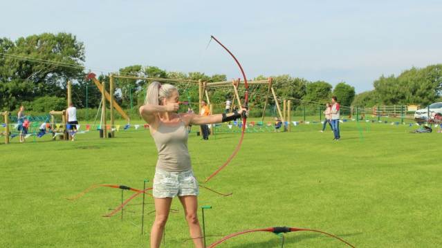 Woman doing archery at Warren Farm Holiday Centre in Burnham on Sea