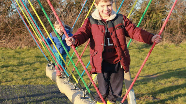 Boys on outdoor playground at Warren Farm Holiday Centre in Burnham-on-Sea