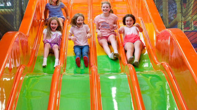 Girls on slide at Snakes and Ladders Play Centre in Brentford