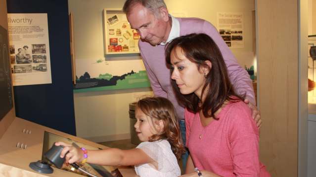 A young girl surrounded by her family plays with an interactive exhibit at St Barbe Museum and Gallery