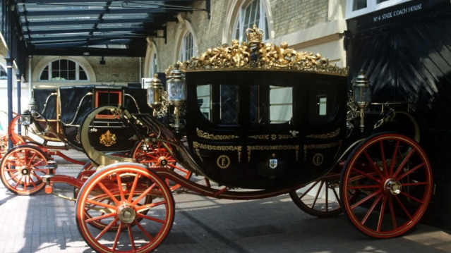 Royal carriages in the State Coach House at the Royal Mews, including ornate state vehicles used for royal ceremonies