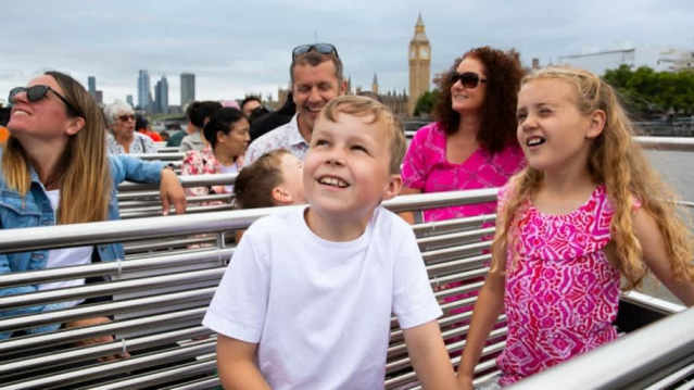Family with children enjoying the London Eye River Cruise with Big Ben in the background